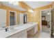 Bright bathroom featuring double sinks, vanity, and an open doorway to a bedroom at 11341 Abercairn Ct, Zionsville, IN 46077