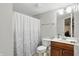 Bathroom features white shower curtain, toilet, and wood vanity at 11341 Abercairn Ct, Zionsville, IN 46077