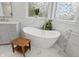 Luxury bathroom featuring soaking tub, marble floors, light gray vanity and ornate windows at 11341 Abercairn Ct, Zionsville, IN 46077