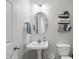 Cozy bathroom with pedestal sink, mirror, and storage shelves at 11341 Abercairn Ct, Zionsville, IN 46077