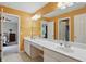 Bathroom with a large mirror, double sinks, vanity, and a bright orange wall at 11341 Abercairn Ct, Zionsville, IN 46077