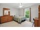 Cozy bedroom with a ceiling fan, dresser and a window offering natural light at 11341 Abercairn Ct, Zionsville, IN 46077