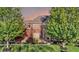 Attractive brick home with a well-manicured lawn and mature trees under a colorful sky at 11341 Abercairn Ct, Zionsville, IN 46077