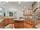 This kitchen is open concept with granite counters, wooden cabinets, stainless steel appliances, and an inviting stone accent at 11341 Abercairn Ct, Zionsville, IN 46077