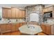 This kitchen boasts custom wood cabinets, granite countertops, stainless appliances, and a stone feature around the cooktop at 11341 Abercairn Ct, Zionsville, IN 46077