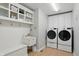 A white laundry room with cabinets and modern washer and dryer at 11341 Abercairn Ct, Zionsville, IN 46077