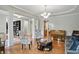 Cozy living room featuring hardwood floors, decorative columns, and an elegant chandelier at 11341 Abercairn Ct, Zionsville, IN 46077