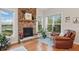 Cozy living room with a stone fireplace, warm hardwood floors, and large windows offering serene outdoor views at 11341 Abercairn Ct, Zionsville, IN 46077