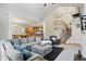 Open-concept living room with vaulted ceilings, plush seating, and seamless flow to the kitchen and staircase at 11341 Abercairn Ct, Zionsville, IN 46077