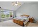 Main bedroom with ceiling fan, large window view, and carpet is painted in pale gray at 11341 Abercairn Ct, Zionsville, IN 46077
