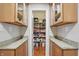 Walk-in pantry with custom wood cabinets and granite countertop provides lots of food storage space at 11341 Abercairn Ct, Zionsville, IN 46077
