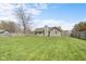 Large, fully fenced backyard with lush green grass, mature trees, and ample space for outdoor activities at 1170 Runningbrook Dr, Avon, IN 46123
