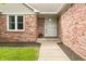 Inviting front entrance featuring red brick, a white trimmed door, and a small pot of flowers at 1170 Runningbrook Dr, Avon, IN 46123