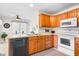 Charming kitchen with light-colored counters, white appliances, wood cabinets and sun-filled eating area at 1170 Runningbrook Dr, Avon, IN 46123