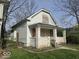 Side view of the boarded up house showcasing the overgrown lawn at 124 N Grant Ave, Indianapolis, IN 46201