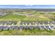 Wide aerial shot of a residential area, showing houses along with a green field, and distant community buildings at 15120 Downham Dr, Fishers, IN 46037