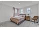 Neutral bedroom with a bed with patterned bedding, a chair, and multiple windows at 15120 Downham Dr, Fishers, IN 46037