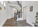Spacious two-story home entryway with hardwood floors and staircase with iron spindles. Doors leading to multiple rooms in the home at 15120 Downham Dr, Fishers, IN 46037