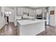 Spacious kitchen island with stainless steel appliances, white cabinets, and hardwood floors that lead into the living spaces at 15120 Downham Dr, Fishers, IN 46037