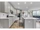 Bright kitchen with white cabinetry, subway tile backsplash, stainless steel appliances, and an island with a quartz countertop at 15120 Downham Dr, Fishers, IN 46037