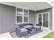 Cozy covered patio seating area with outdoor furniture and sliding glass door access to the home at 15120 Downham Dr, Fishers, IN 46037