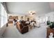 Open-concept living room with modern furnishings, including a leather sofa and views of the kitchen and dining area at 16204 Oakford Trl, Fishers, IN 46037