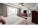 Bright main bedroom with a bay window, ceiling fan and a large dresser with wall mounted television at 16204 Oakford Trl, Fishers, IN 46037