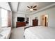 Spacious main bedroom featuring a ceiling fan, tray ceiling, and large windows with modern furnishings at 16204 Oakford Trl, Fishers, IN 46037