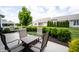 Patio area with four chairs, a fire pit table, and manicured landscaping at 16204 Oakford Trl, Fishers, IN 46037