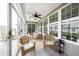 Cozy sunroom with wicker furniture, ceiling fan, tiled flooring, and backyard view at 16204 Oakford Trl, Fishers, IN 46037