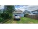 Backyard with a parked car, green lawn, and trees, creating a serene outdoor space at 1641 N Cornell Ave, Indianapolis, IN 46202