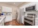 Well-equipped kitchen with stainless steel refrigerator, microwave, and oven with white cabinets at 1641 N Cornell Ave, Indianapolis, IN 46202