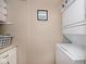 Compact laundry area with stacked washer and dryer and shelving for storage at 1641 N Cornell Ave, Indianapolis, IN 46202