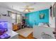 A modern bedroom decorated with a vibrant blue accent wall, ceiling fan, and eclectic decor at 1840 W 100 N, Columbus, IN 47201