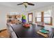 A cozy dining room with a large dining table, ceiling fan, and natural light from the window at 1840 W 100 N, Columbus, IN 47201