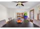 A dining room with view to kitchen, complete with a ceiling fan and natural light streaming in from the window at 1840 W 100 N, Columbus, IN 47201