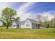 View of the home featuring large windows and a well-maintained lawn at 1840 W 100 N, Columbus, IN 47201