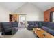 Comfortable living room features reclining furniture, neutral carpet, and access to the screened in porch at 1840 W 100 N, Columbus, IN 47201
