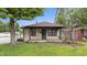 Charming single-story home featuring a cozy front porch and mature trees in a serene neighborhood at 1953 N Alton Ave, Indianapolis, IN 46222