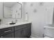 Elegant bathroom featuring a gray vanity, decorative star accents, and a framed mirror at 2226 Central Ave, Indianapolis, IN 46205