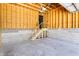 Unfinished two-car garage with concrete floor, block foundation, wooden framing, and a storage loft with stair access at 2226 Central Ave, Indianapolis, IN 46205