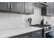 A close up of a kitchen featuring quartz countertops, stainless steel appliances, and gray cabinets at 2226 Central Ave, Indianapolis, IN 46205