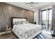 Modern main bedroom featuring a diamond accent wall, a ceiling fan and access to an outdoor balcony at 2226 Central Ave, Indianapolis, IN 46205