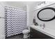 Bathroom features a tub shower with a modern chevron curtain, a vanity, and an oval mirror at 223 Haldale Dr, Carmel, IN 46032