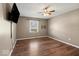 A cozy bedroom with a wood-look floor, a ceiling fan, and natural light coming from a window at 223 Haldale Dr, Carmel, IN 46032