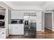Bright kitchen featuring stainless steel refrigerator, white cabinetry, and rich hardwood floors at 223 Haldale Dr, Carmel, IN 46032