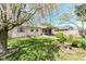 Backyard with well-maintained lawn, mature tree, garden and covered patio at 251 S 12Th Ave, Beech Grove, IN 46107