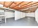Unfinished basement with painted floor and walls, visible ceiling, shelving and stairs at 251 S 12Th Ave, Beech Grove, IN 46107