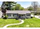 Inviting home with manicured lawn and blue trim offers great curb appeal at 251 S 12Th Ave, Beech Grove, IN 46107