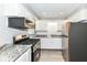 View of kitchen with stainless steel appliances, granite countertops, hardwood floors and neutral walls at 251 S 12Th Ave, Beech Grove, IN 46107